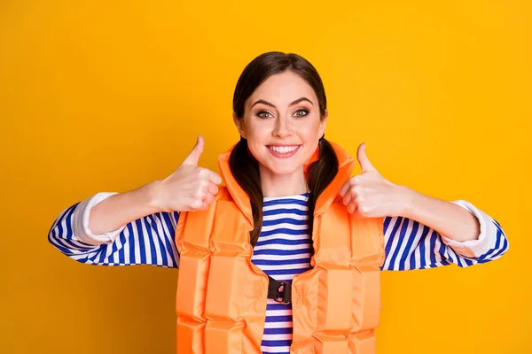 Foto portret van vrij tevreden zelfverzekerde dame met twee haarstaarten in gestreept shirt oranje reddingsvest maken vingers omhoog teken geïsoleerd over gele kleur achtergrond — Stockfoto