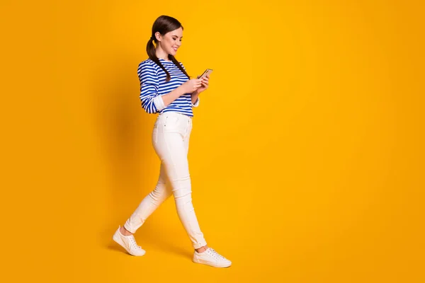 Foto lateral de perfil de tamaño completo del uso de la chica positiva del teléfono celular tienen comunicación en las redes sociales escalofriante desgaste ropa blanca zapatos aislados sobre brillante brillo de fondo de color —  Fotos de Stock