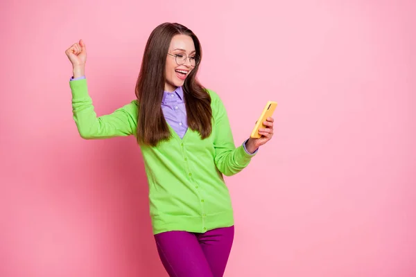 Photo of delighted girl use smartphone win raise fists scream wear shirt pants trousers isolated pastel color background — Stock Photo, Image