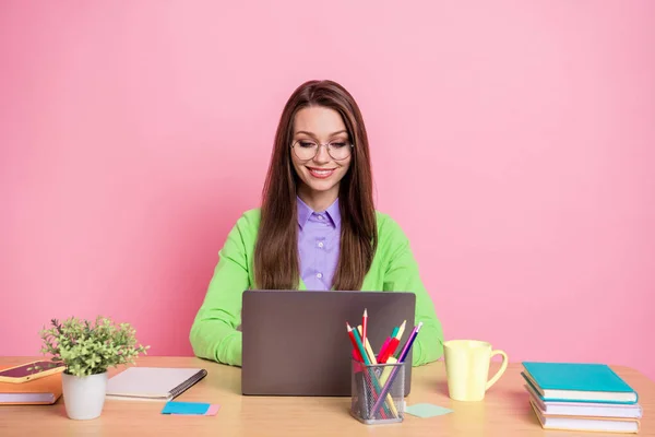 Portret skupionej dziewczyny siedzieć stół pracy laptop nosić zieloną koszulę izolowane na pastelowym tle koloru — Zdjęcie stockowe