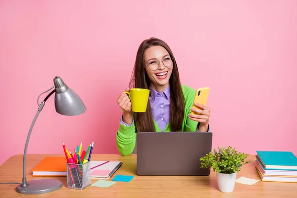 Positivo menina do ensino médio sentar mesa uso digital smartphone rir desgaste verde camisa isolado pastel cor fundo — Fotografia de Stock