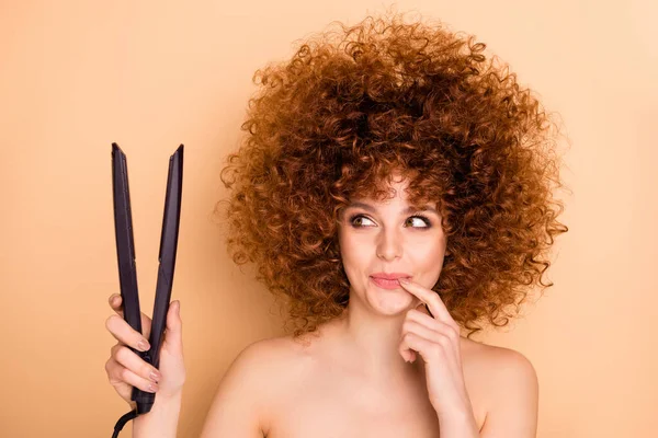 Close-up portrait of her she nice cute attractive lovely groomed cheerful feminine wavy-haired girl looking holding in hands iron straightener planning isolated over beige pastel background — Stock Photo, Image