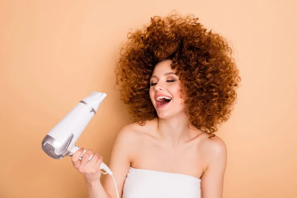 Close-up portrait of nice cute attractive lovely well-groomed dreamy positive cheerful cheery wavy-haired girl drying curls body bodycare having fun isolated over beige pastel background — Stock Photo, Image