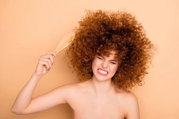 Close-up ritratto di lei lei bella carino attraente nervoso negativo ondulato dai capelli teen girl cercando di pettinare caos coccole corpo cura isolato su sfondo beige pastello — Foto Stock