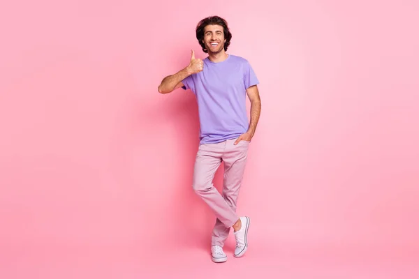 Foto de longitud completa de bolsillo de mano chico levantar el pulgar hacia arriba usar pantalones de camisa violeta zapatillas aisladas pastel de color rosa fondo — Foto de Stock