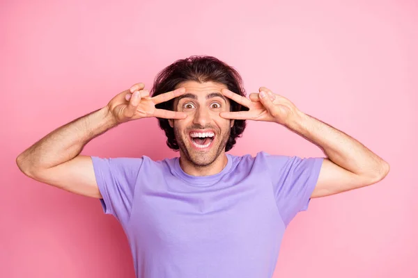 Photo de funky guy deux mains montrer v-signe bouche ouverte dents sourire porter violet t-shirt isolé couleur rose pastel fond — Photo