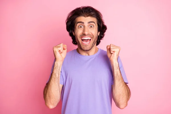 Foto di ragazzo stupito alzare i pugni bocca aperta indossare viola t-shirt isolato colore rosa pastello sfondo — Foto Stock