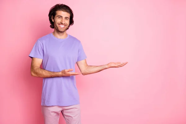 Retrato de persona guapo sostiene producto dos brazos palmeras espacio vacío aislado sobre fondo de color rosa pastel —  Fotos de Stock