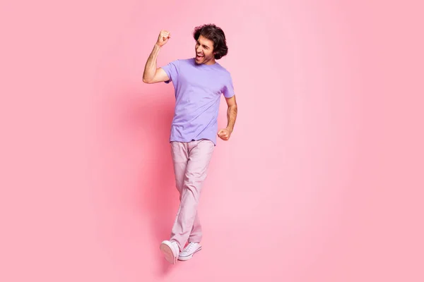 Full size photo of astonished fan person walking yell yes fist up wear purple isolated on pink color background — Stock Photo, Image