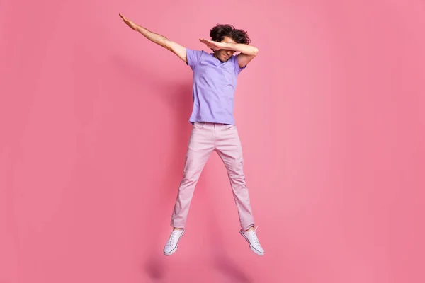 Teljes hosszúságú fotó barna hajú sörényes sportos fickó ugrik fel dab fedél szemek viselni rózsaszín nadrág elszigetelt rózsaszín színű háttér — Stock Fotó