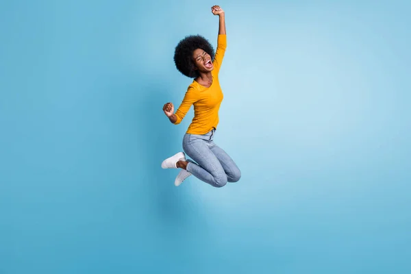 Foto porträtt full storlek aktiv brunett flicka hoppar upp firar isolerad på pastell blå färgad bakgrund — Stockfoto