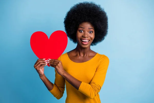 Portrait photo d'une heureuse femme à la peau noire souriante gardant le symbole en papier rouge du cœur amoureux isolé sur un fond de couleur bleu vif — Photo