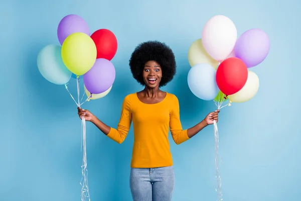 Φωτογραφία πορτρέτο του κατάπληκτος χαρούμενος μαύρο δέρμα κορίτσι κρατώντας σωρός από πολύχρωμα μπαλόνια αέρα γέλιο απομονώνονται σε ζωντανό φόντο μπλε χρώμα — Φωτογραφία Αρχείου