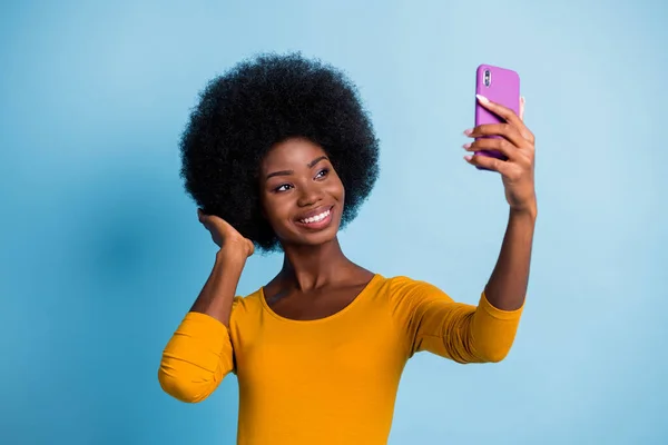 Foto portret van mooie zwarte huid meisje nemen selfie glimlachen aanraken kapsel geïsoleerd op levendige blauwe kleur achtergrond — Stockfoto