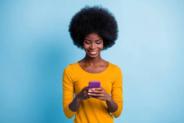 Foto-Porträt von hübschen schwarzhäutigen Mädchen mit Smartphone-SMS lächelnd isoliert auf lebendigem blauem Hintergrund — Stockfoto