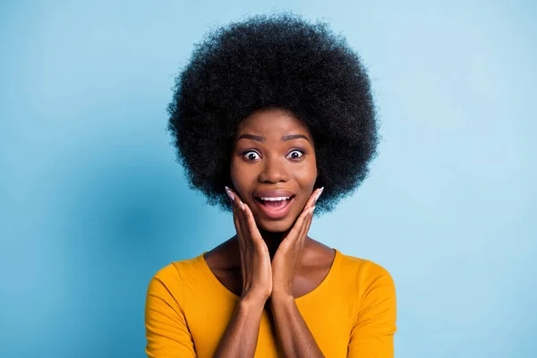 Fotografie roztomilé černošky dívka objem účes otevřená ústa paže tváře šílený tvář nosit žlutou košili izolované modré barvy pozadí — Stock fotografie