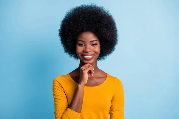 Foto de inteligente linda chica volumen peinado brillante sonrisa de dientes pensar dedo barbilla desgaste amarillo camisa aislado color azul fondo —  Fotos de Stock