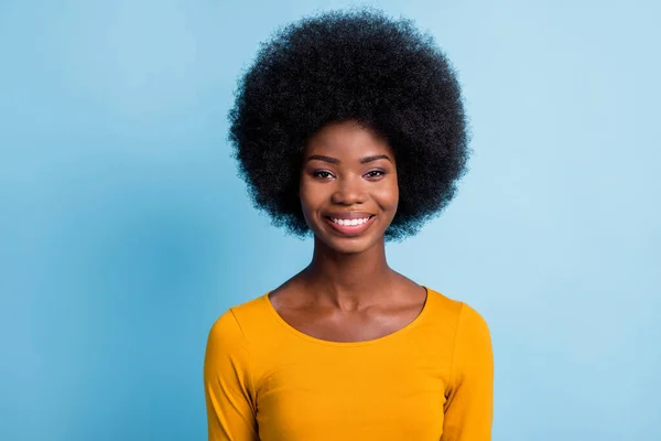 Foto de encantador preto jovem senhora olhar câmera de dente brilhante sorrindo desgaste amarelo camisa isolada azul cor de fundo — Fotografia de Stock