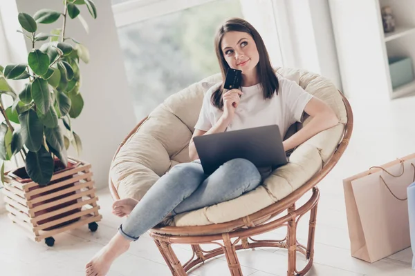 Photo of minded girl siedzieć krzesło używać laptopa do zakupu hold bank myśleć w domu w pomieszczeniach — Zdjęcie stockowe