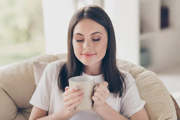 Portret van dromerig mooi meisje zit stoel geur aromatische koffie kopje in huis binnen — Stockfoto