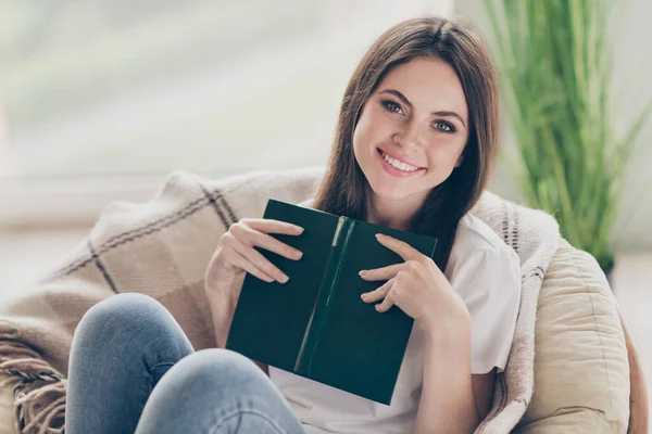 Photo of pretty young girl siedzieć wiklinowy fotel trzymać książki papieru nosić casual stylu ubrania w domu w pomieszczeniach — Zdjęcie stockowe