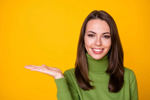 Retrato de cerca de una chica bastante alegre sosteniendo en el espacio de copia de la palma anuncio aislado sobre el fondo de color amarillo brillante — Foto de Stock