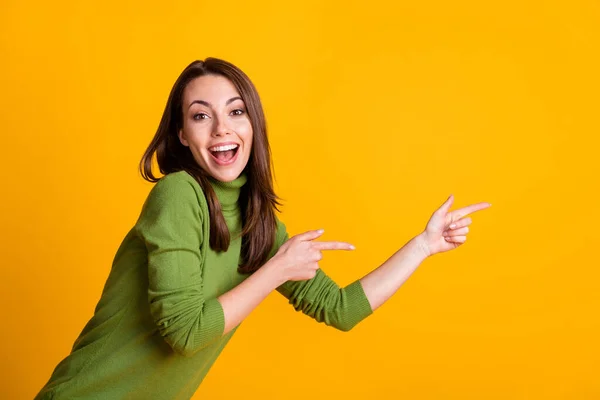 Kuva hauska nainen suora sormet puolella tyhjä tila osoittaa myynti kulumista vihreä villapaita eristetty keltainen väri tausta — kuvapankkivalokuva