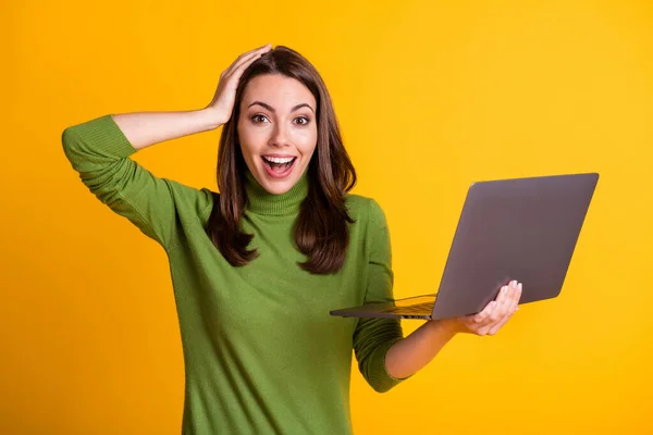 Fotografie atraktivní vzrušená dáma na volné noze pracovník držet notebook nosit zelený svetr izolované žluté barvy pozadí — Stock fotografie