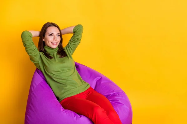 Foto der netten Dame sitzen Komfort violette Bohnentasche Hände hinter dem Kopf Blick nach oben tragen Pullover Hose isoliert gelbe Farbe Hintergrund — Stockfoto