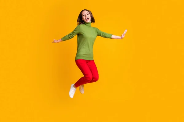 Teljes hosszúságú fotó őrült hölgy ugrik fel elterjedt karok viselése pulóver tornacipő nadrág elszigetelt sárga színű háttér — Stock Fotó