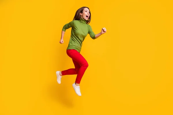 Foto em tamanho completo de senhora engraçada saltar para cima apressando desgaste animado casual verde pulôver sapatos vermelho calças isoladas cor amarela fundo — Fotografia de Stock