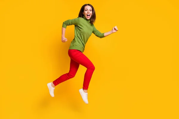 Full length profile photo of crazy lady jump up βιασύνη φορούν casual πουλόβερ παπούτσια κόκκινο παντελόνι απομονωμένο κίτρινο χρώμα φόντο — Φωτογραφία Αρχείου
