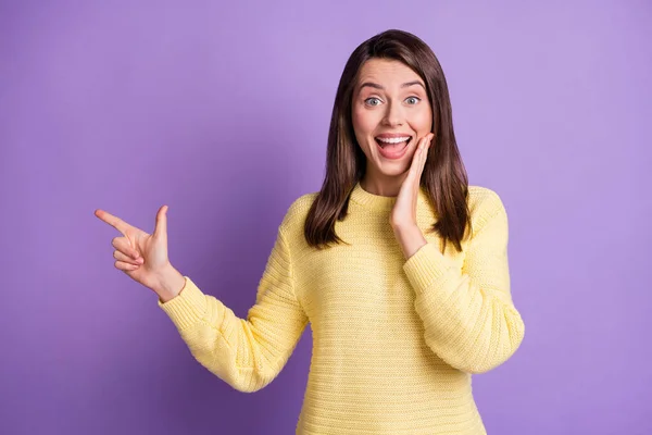 Foto retrato de mulher espantada apontando um dedo para o espaço em branco tocando rosto com a mão isolada no fundo colorido roxo vívido — Fotografia de Stock