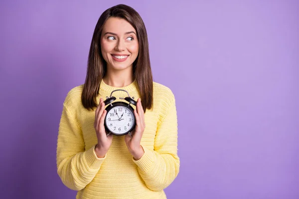Foto retrato de mulher segurando relógio preto em duas mãos olhando para o espaço em branco sorrindo isolado no fundo colorido violeta vívido — Fotografia de Stock