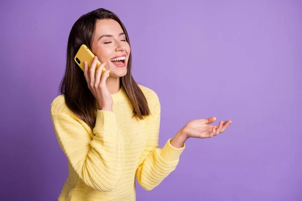 밝은 보라색 배경에 빈 칸을 손에 들고 노란 핸드폰을 웃으며 이야기하는 여성의 사진 — 스톡 사진