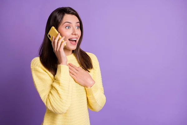 Foto retrato de mulher surpreendida falando sobre celular amarelo tocando peito isolado em fundo colorido roxo vívido — Fotografia de Stock