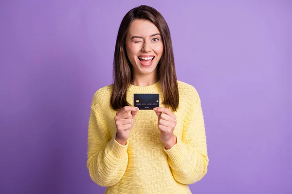 Fénykép portré csinos lány villog vidáman mutatja bank hitelkártya mosolygó visel sárga ruhát elszigetelt élénk lila színű háttér — Stock Fotó