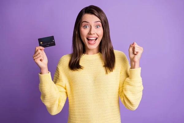 Foto retrato de chica alegre asombrada manteniendo tarjeta de crédito bancaria gesto como sonrisa ganadora aislado sobre fondo de color púrpura brillante — Foto de Stock