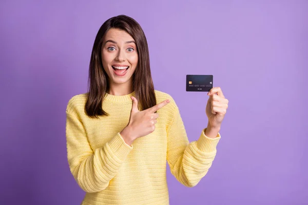 Foto porträtt av brunett kvinna som innehar bankkort med öppen mun isolerad på levande lila färgad bakgrund — Stockfoto