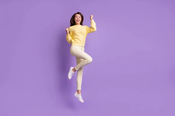 Φωτογραφία πορτρέτο πλήρη θέα του σώματος χαρούμενη γυναίκα γιορτάζει με δύο γροθιές στον αέρα άλμα επάνω απομονωμένη σε ζωντανό βιολετί χρώμα φόντο — Φωτογραφία Αρχείου