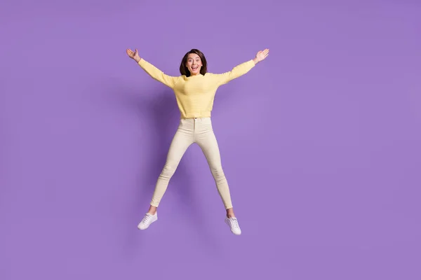 Ritratto fotografico a figura intera di ragazza eccitata che salta su allargando le braccia gambe come la stella isolata su un vivido sfondo di colore viola — Foto Stock