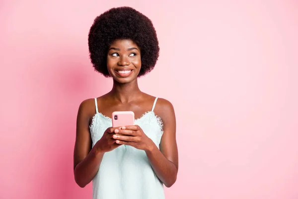 Foto van bruin krullend haar mooie jonge vrouw kijken copyspace denk commentaar houden telefoon slijtage singlet geïsoleerd op roze kleur achtergrond — Stockfoto