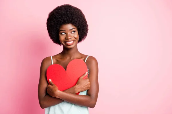 Foto di attraente capelli ricci signora mani tenere il cuore forma di carta usura blu singoletto isolato su sfondo di colore rosa — Foto Stock