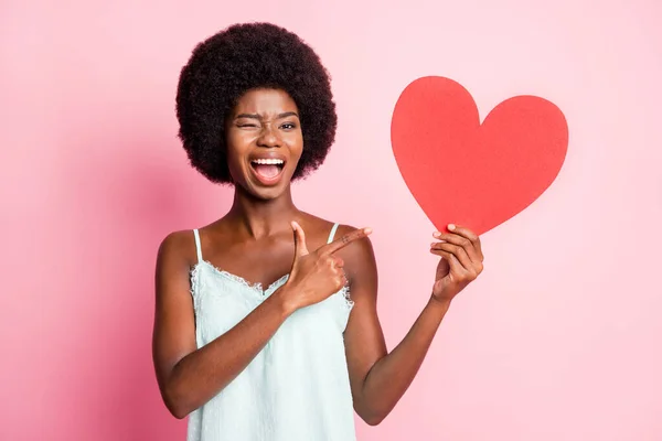 Foto de hermoso peinado rizado ojo de la señora guiño dedo directo símbolo rojo singlet azul aislado sobre fondo de color rosa —  Fotos de Stock