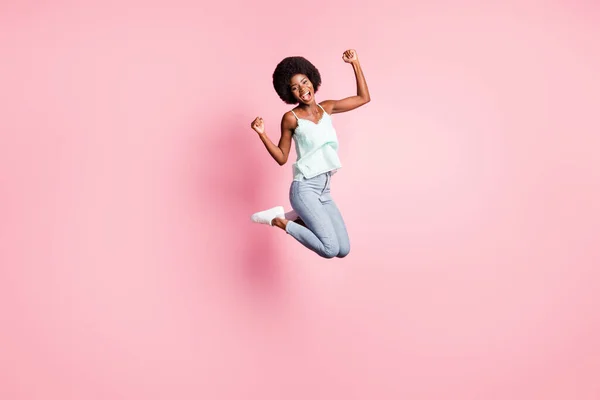 Full-Size-Porträt von attraktiven lockigen Frisur Person springen hohe Fäuste nach oben offenen Mund isoliert auf rosa Hintergrund — Stockfoto