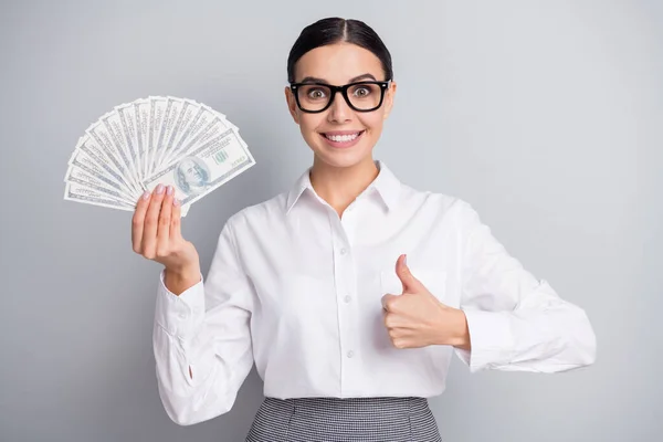 Photo of business woman hold fan cash podnieść kciuk w górę nosić okulary biała koszula odizolowany szary kolor tła — Zdjęcie stockowe