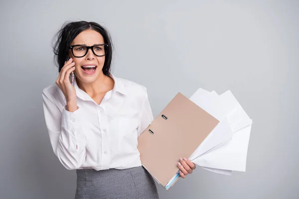 Foto de llorando triste niña hablar teléfono inteligente sostener la carpeta documentos usar gafas camisa blanca aislado fondo de color gris — Foto de Stock