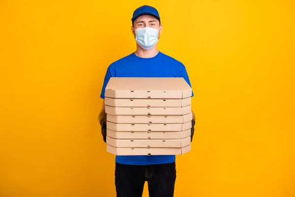 Fénykép a szállító tartsa pizza dobozok viselni kalap hideg biztonságos egészségügyi légzőkészülék elszigetelt sárga színű háttér — Stock Fotó