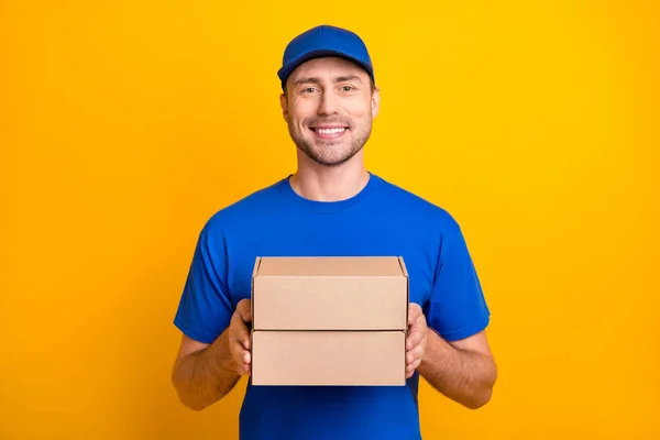 밝은 노란색 배경에 분리되어 있는 웃음 상자를 들고 있는 우호적 인 일하는 사람의 모습 — 스톡 사진