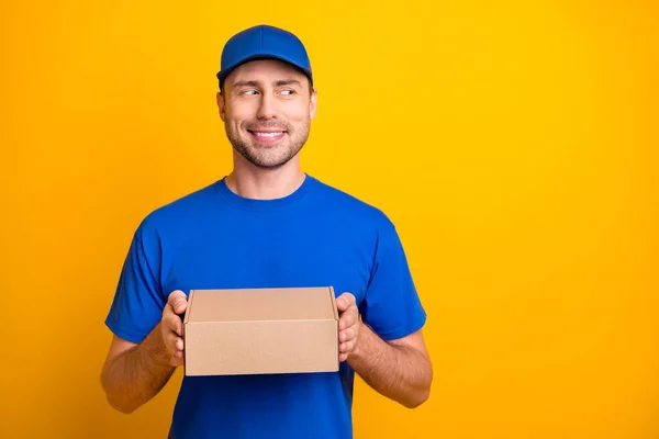 Foto von schönen Kerl Arme halten Paket tragen Hut aussehen leeren Raum isoliert auf gelber Farbe Hintergrund — Stockfoto